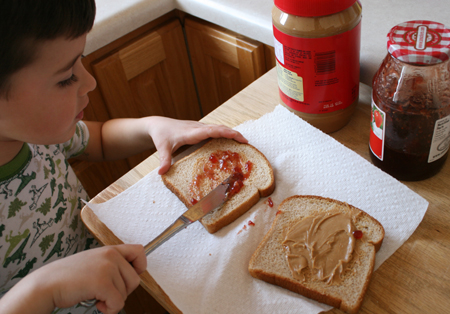 Making his own Peanut Butter & Jelly Sandwich. It may not look pretty, 