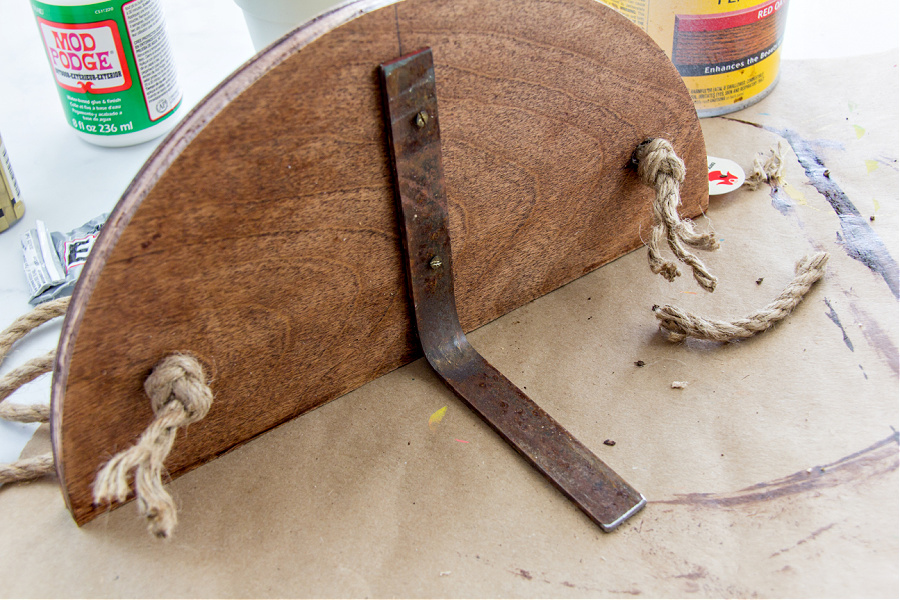 a bracket mounted underneath a wood planter