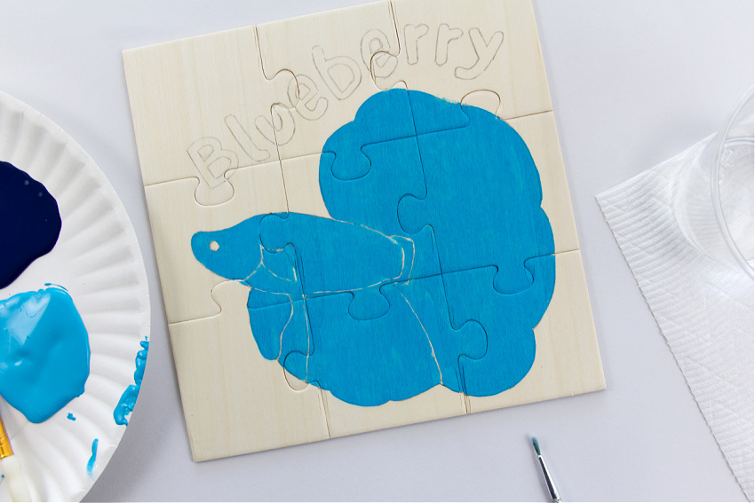 a blue betta fish painted on a wood puzzle
