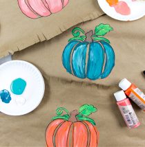 a pumpkin painted on brown paper and turned into a paper placemat for the kids Thanksgiving table