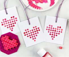 Valentine's Day cards made using LEGO pieces dipped in paint to make a LEGO heart