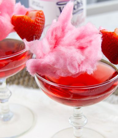 a pink cotton candy mocktail with a strawberry heart garnish