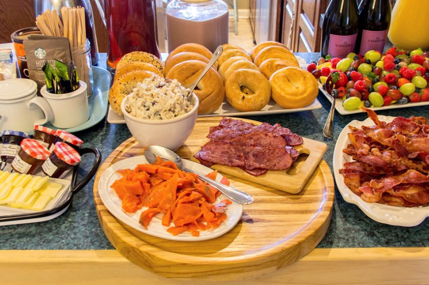 bagel bar with salmon, bacon, chicken salad, and other toppings