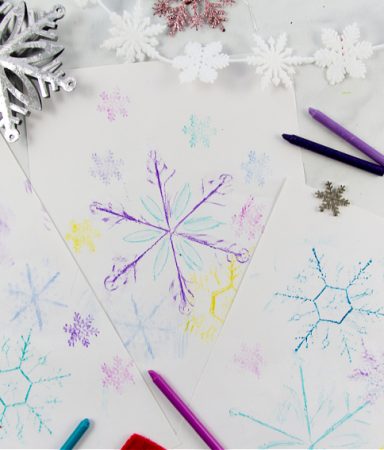 snowflake art rubbings using crayons and Christmas snowflake ornaments