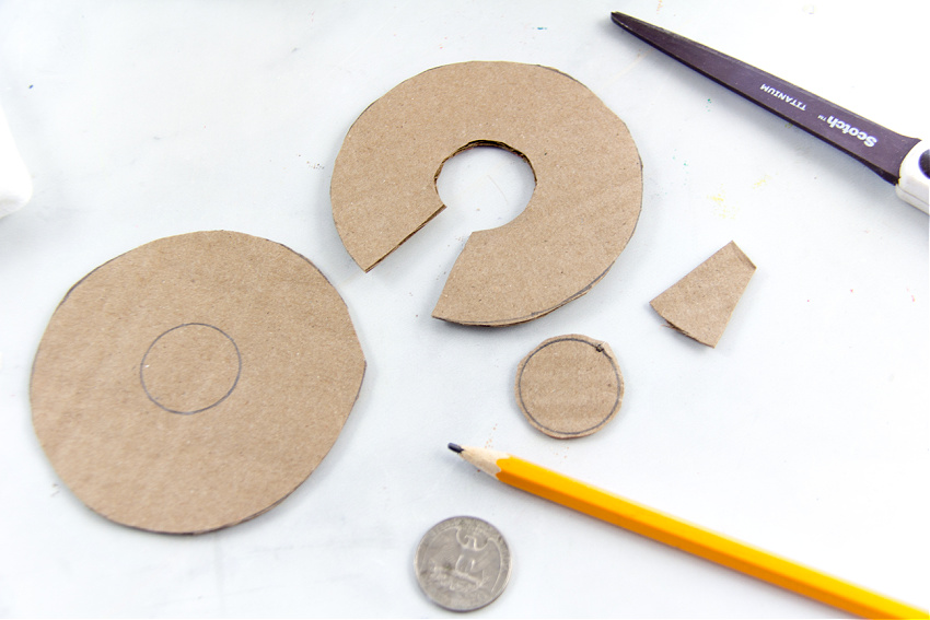 Two rings cut out of a cardboard box to make a pom pom