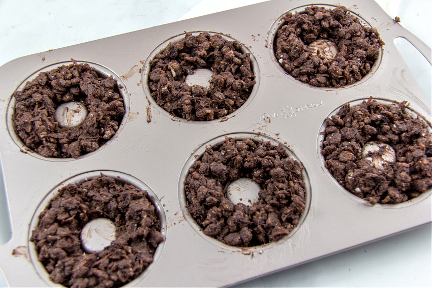 chocolate crackle mixture pressed into a donut pan to make christmas wreaths