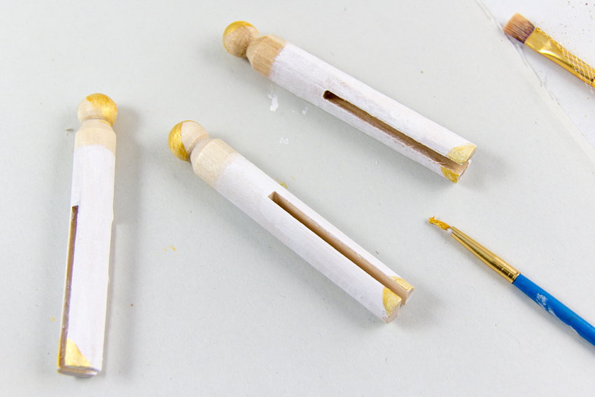 a clothespin painted with white and gold paint to make an angel