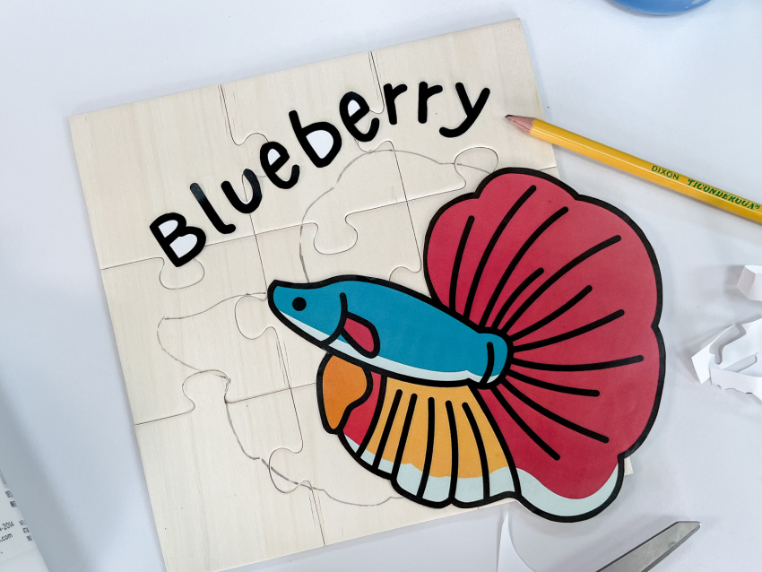 a betta fish traced onto a wood magnet puzzle with the name of the fish