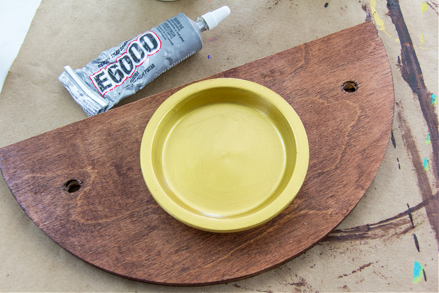 a terracotta saucer attached to a wood hanging planter