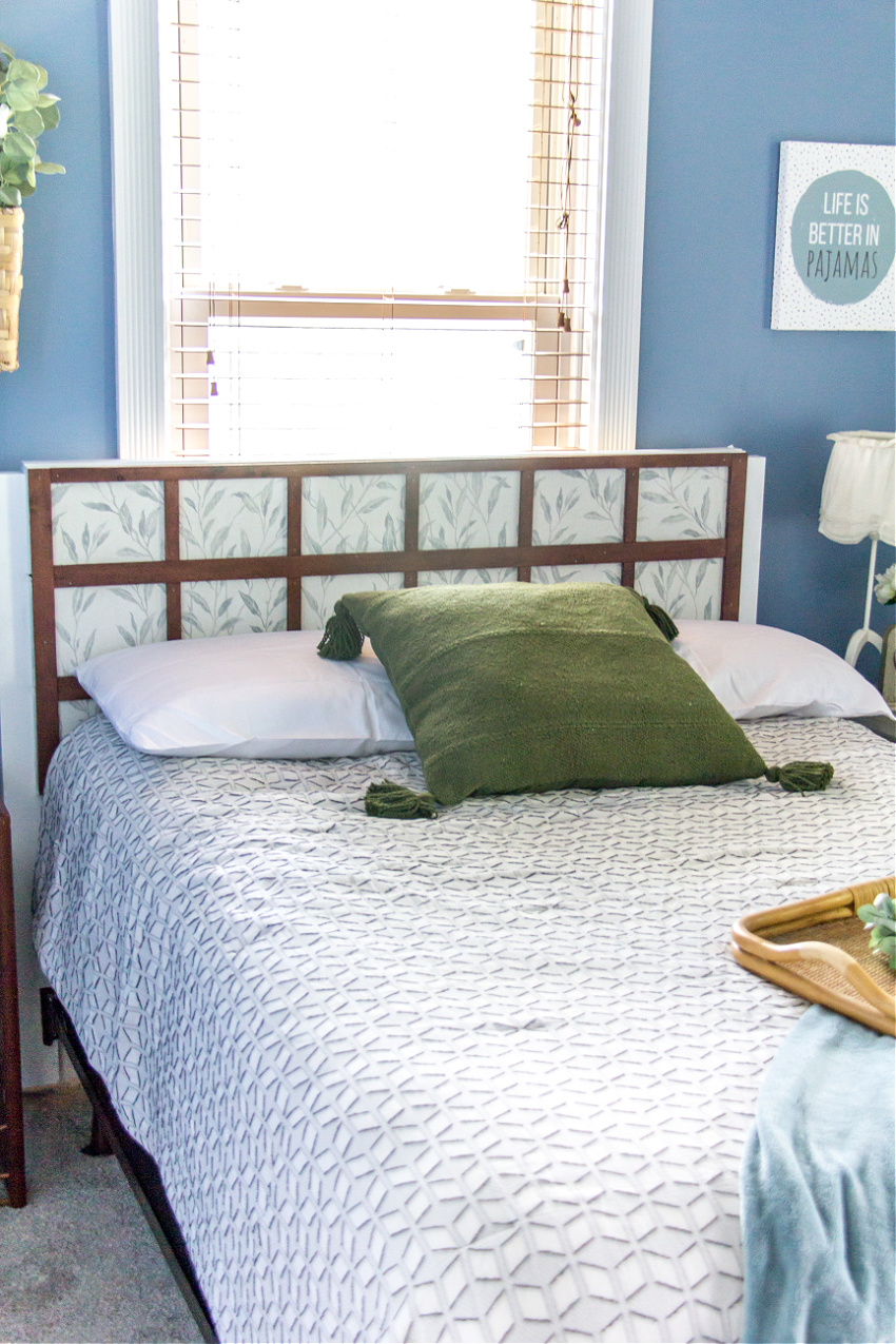 a nature themed bedroom with green, blue, and white and a DIY wood headboard