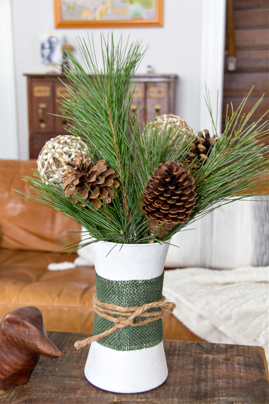 a glass vase painted white and wrapped with burlap and twine for winter decorating