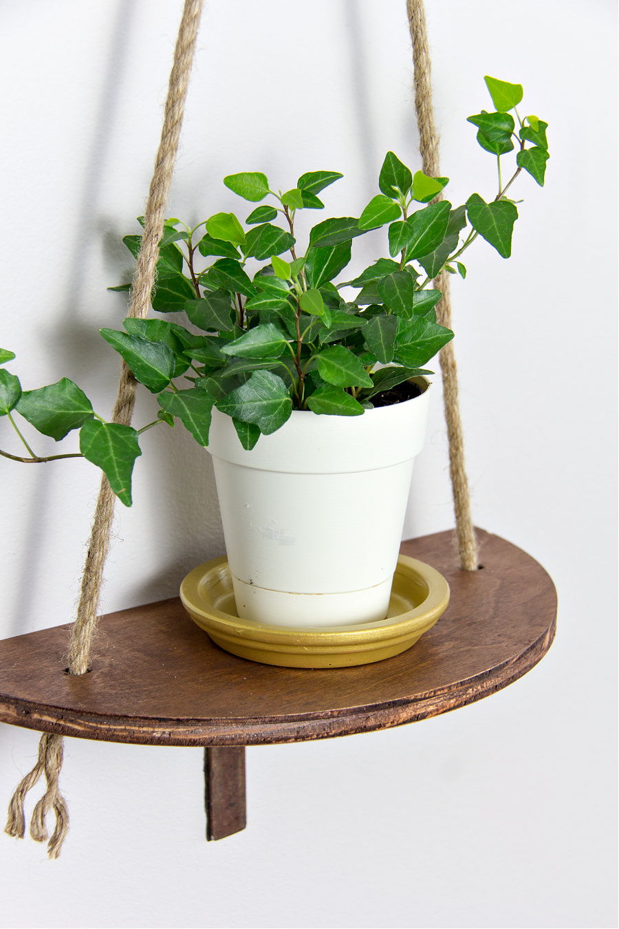 a diy wood hanging planter with jute cord and a gold terracotta saucer