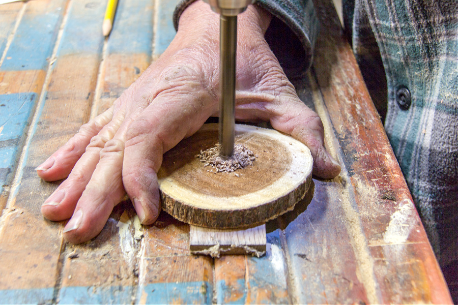 a hole being drilled into a wood slice