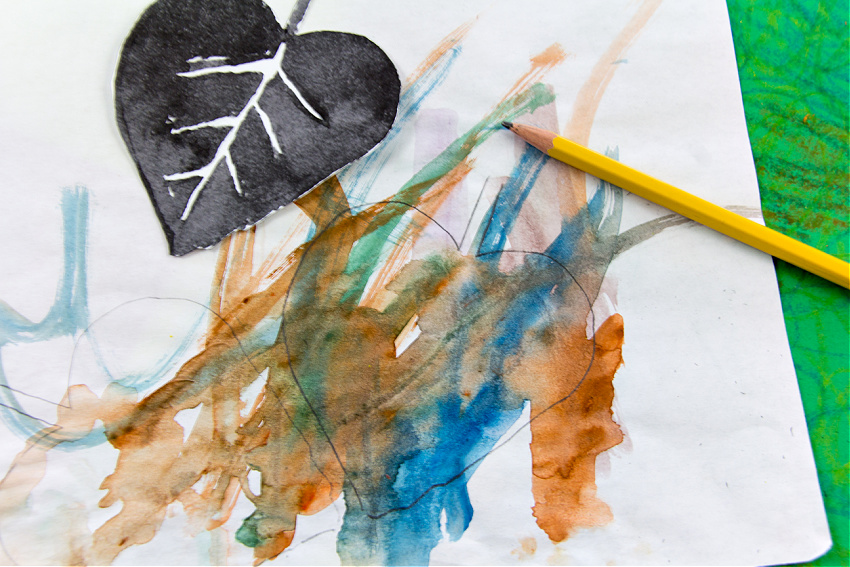 a leaf shape drawn over children's watercolor art