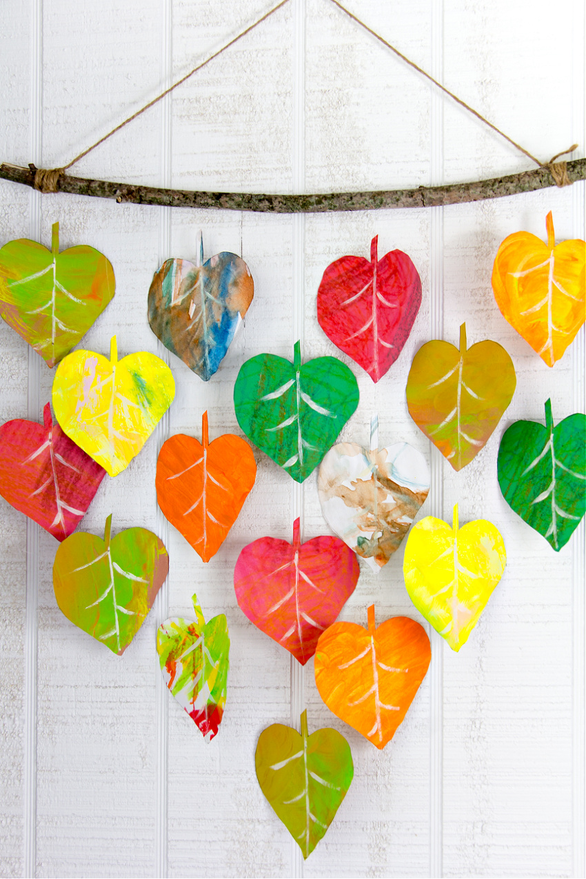 red, orange, yellow, brown, and green kids artwork cut into leaf shapes and made into fall wall decor