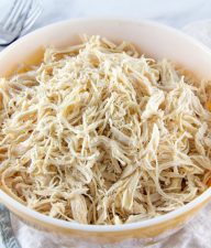 A vintage yellow bowl full of shredded chicken