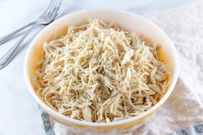 A vintage yellow bowl full of shredded chicken