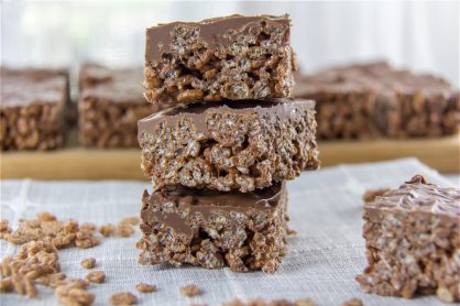 chocolate rice krispies treats stacked and a wood cutting board