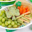 a st patricks day food tray with shamrock quesadillas, vegetable straws, carrot sticks, and green grapes