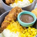fried chicken strips, mashed potatoes, corn, and gravy in a bowl