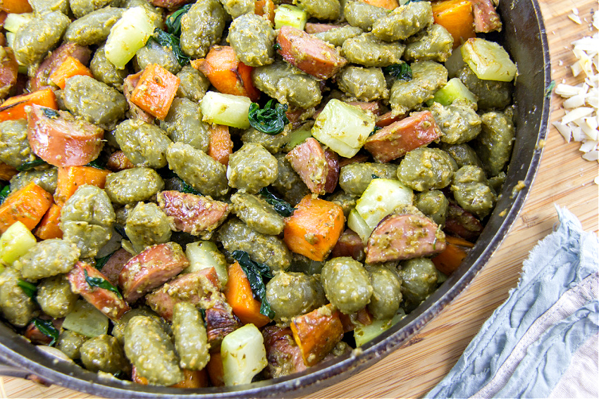 gnocchi sweet potato, squash, kielbasa, pesto, spinach, and mascarpone in a cast iron skillet