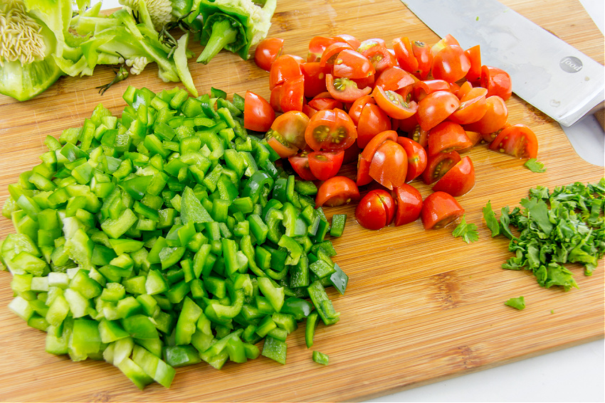 green peppers, grape tomatoes, and cilantro chopped for a street corn salad