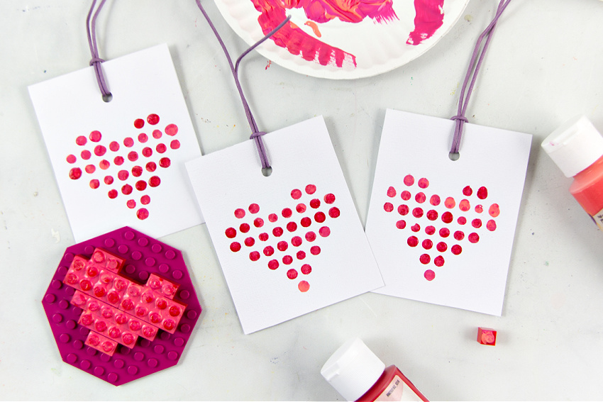 Valentine's Day cards made using LEGO pieces dipped in paint to make a LEGO heart