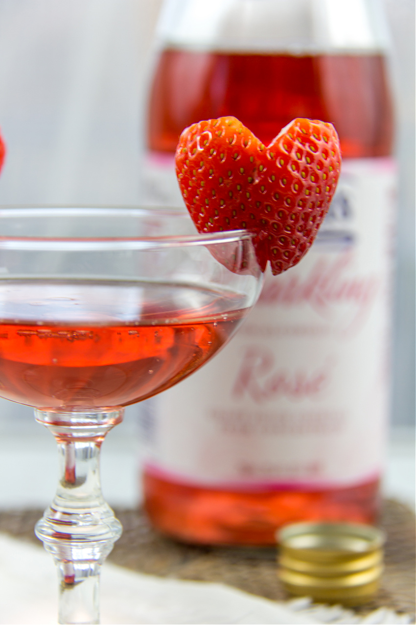 a heart shaped strawberry on the rim of a glass