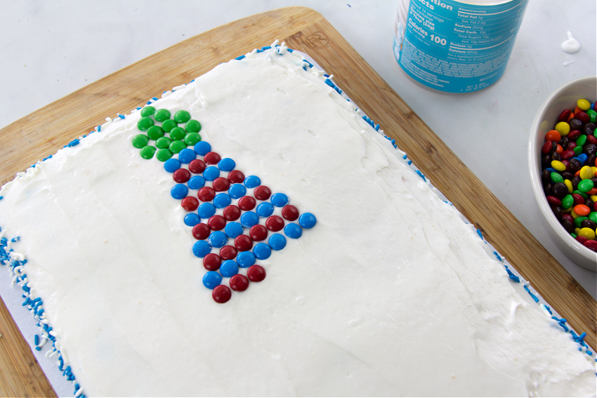 A tie being made on a cake using M&M's.