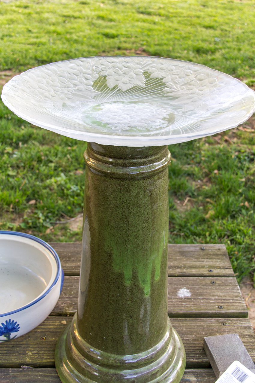 a large round glass tray glued to a bird bath base
