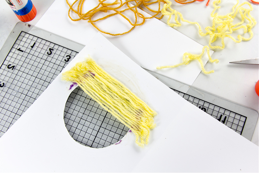 yarn scraps being glued over the back of a greeting card