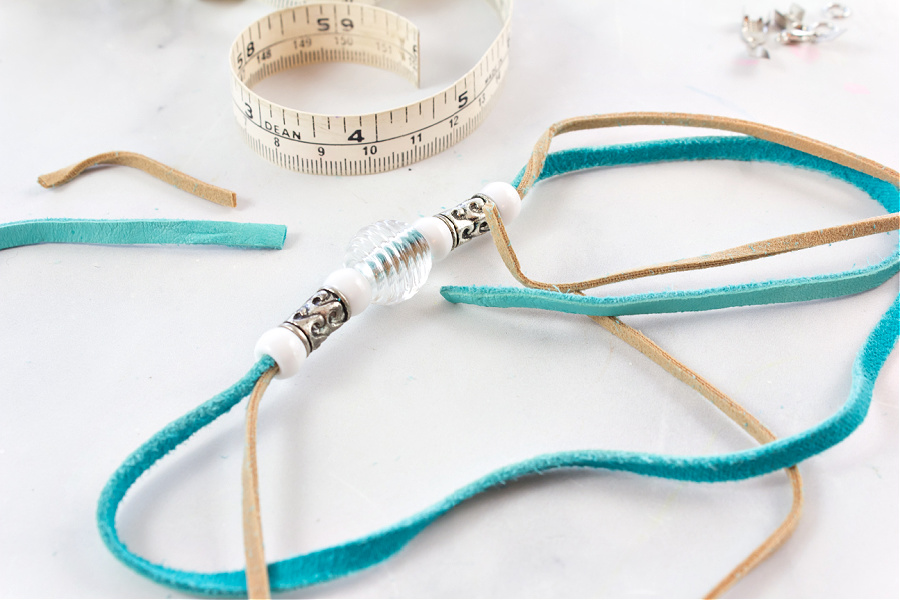 beads threaded onto two strands of faux leather cord to make a bracelet