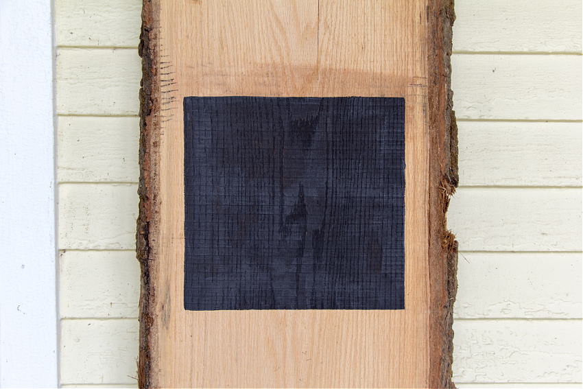 a black box painted on a piece of white oak to make a porch sign