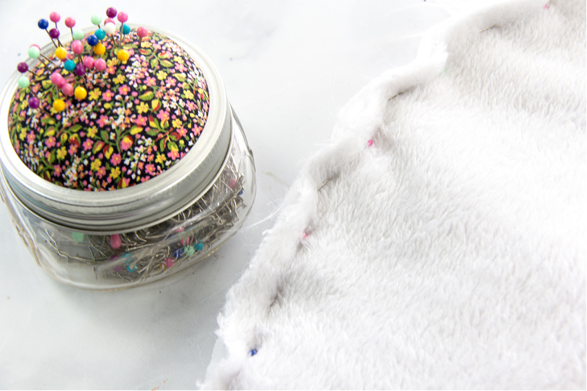 plush fabric being sewn into a circular dog bed