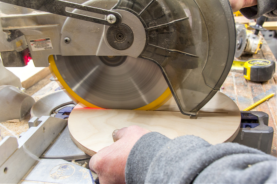 a wood circle being cut in half to make a hanging planter