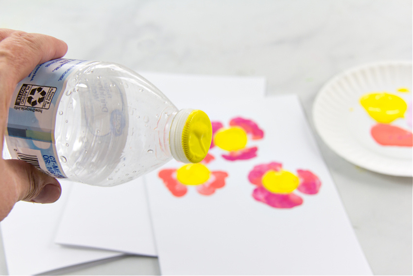 the lid of a plastic water bottle with paint on it to make the center of a flower