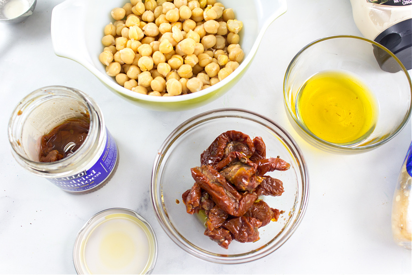 bowls of garbanzo beans, sundried tomatoes, and oil to make hummus