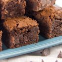 thicky fudgy brownies stacked on a blue tray