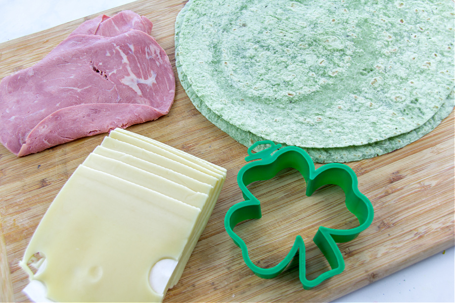 spinach wraps, corned beef lunch meat, and Swiss cheese slices with a shamrock cookie cutter to make shamrock quesadillas