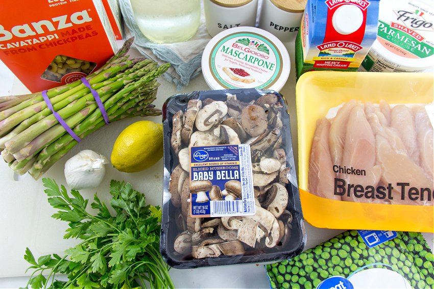 ingredients to make spring pasta with grilled chicken, asparagus, mushrooms, peas, and lemon