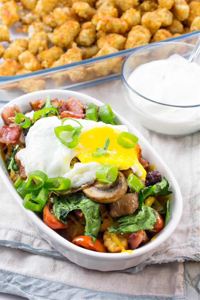 loaded tater tots for breakfast topped with a fried egg