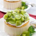 mini angel food cake topped with whipped cream, green grapes, and kiwi fruit
