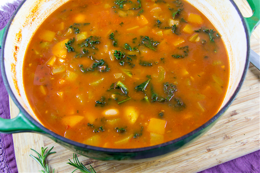 a large pot of soup with fresh vegetables and kidney beans