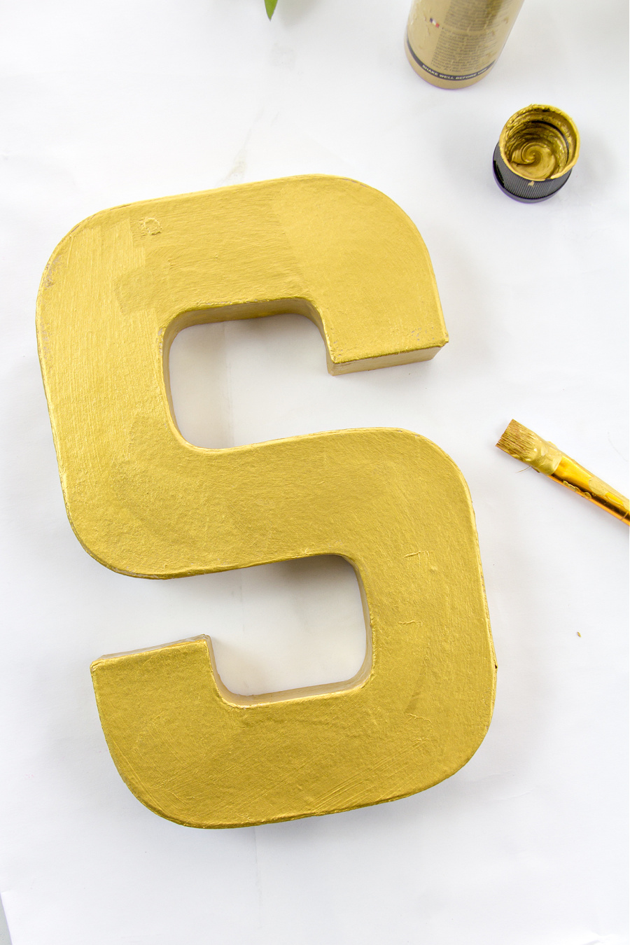 a paper mache letter S painted gold