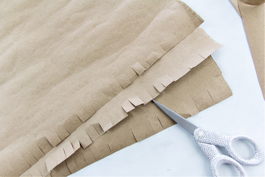 paper placemats craft for preschoolers that uses fine motor skills to cut a fringe around the paper.