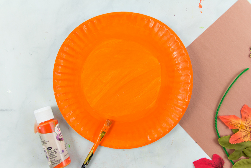 a paper plate painted with orange paint