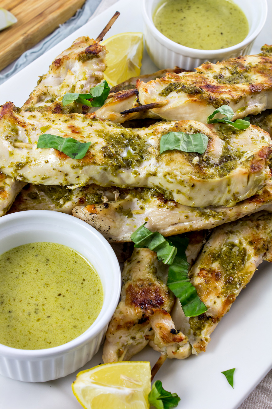 pesto chicken kabobs cooked on the grill with mascarpone dipping sauce in small bowls