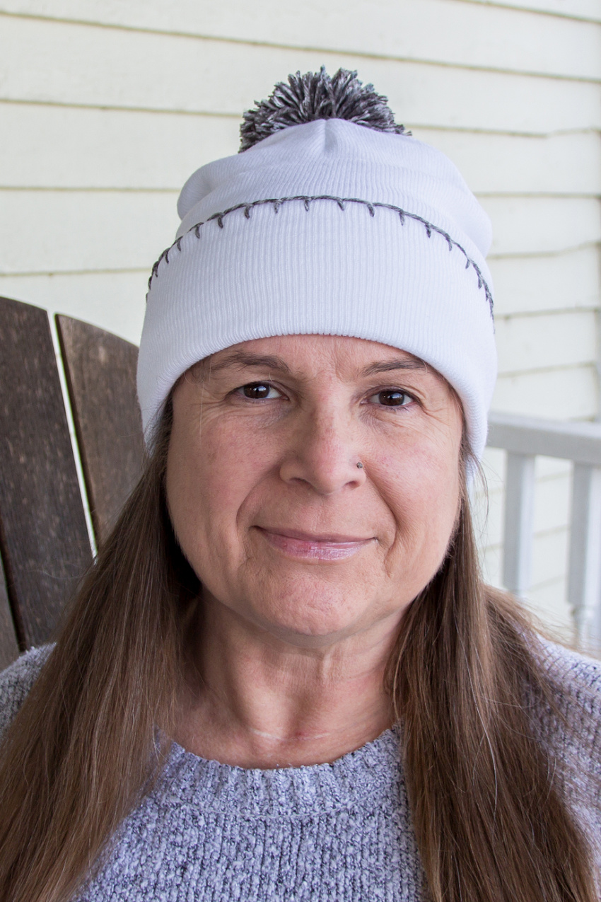 a plain white beanie with embroidery and a pom pom added