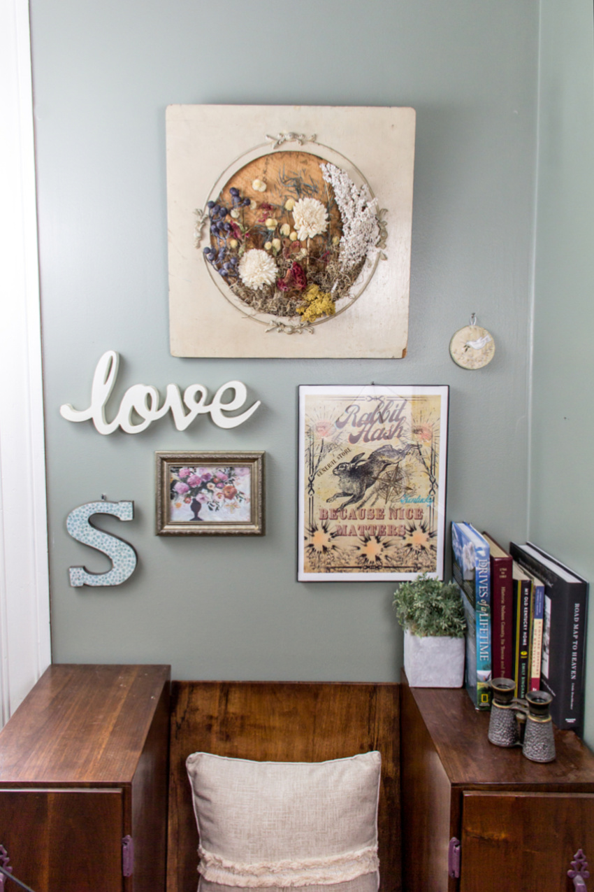 A reading nook with a gallery wall including dried flower wall art