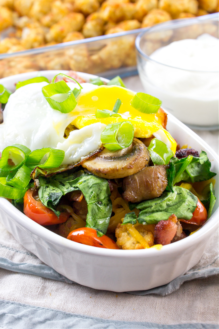 loaded tater tots recipe with bacon, sausage, egg, tomato, mushrooms, and spinach